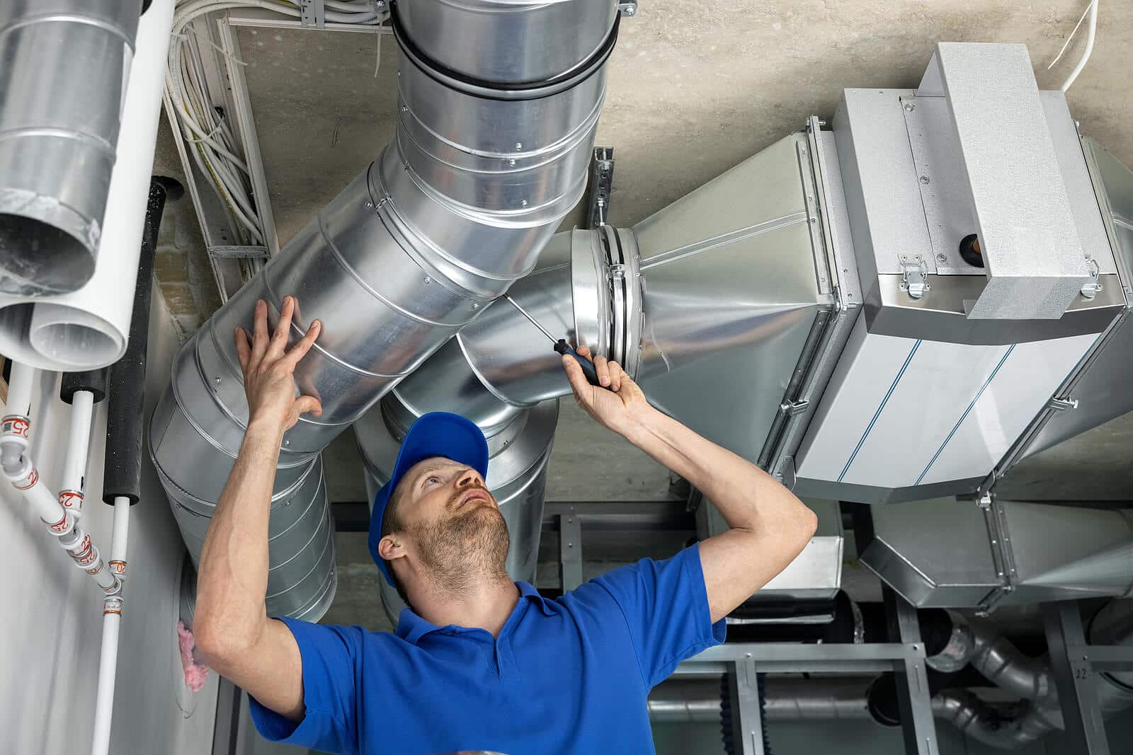 HVAC technician inspecting and repairing air ducts in Davis