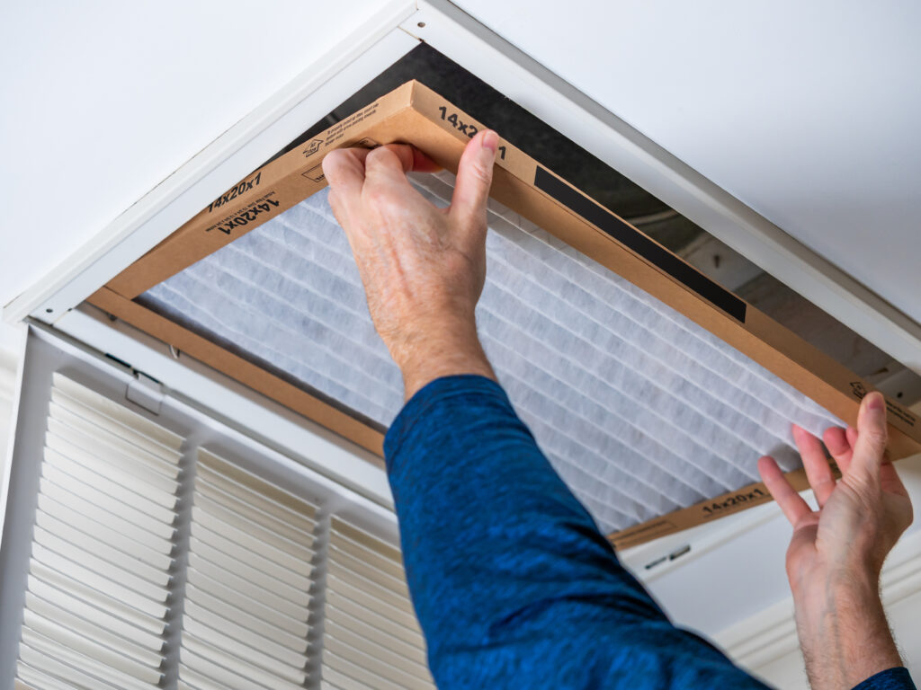 HVAC technician replacing a home air filter in Davis