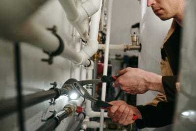 Technician inspecting commercial plumbing pipes in Davis