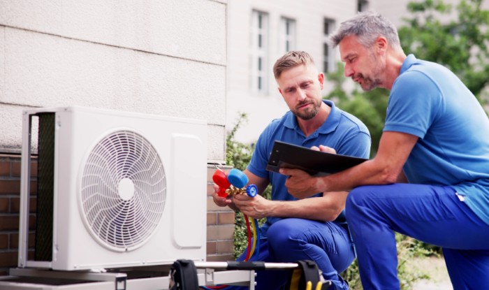 HVAC technicians installing an outdoor air conditioning unit in Davis