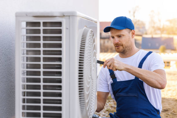 HVAC technician servicing an outdoor air conditioner in Davis