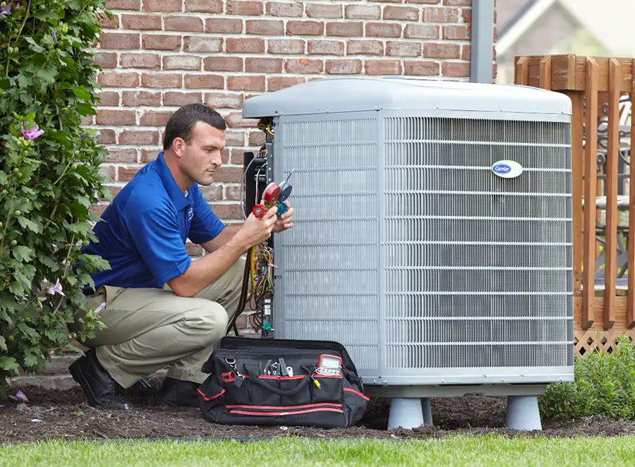 HVAC technician inspecting an outdoor AC unit in Davis