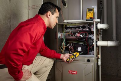 Heating technician diagnosing a furnace repair in Davis