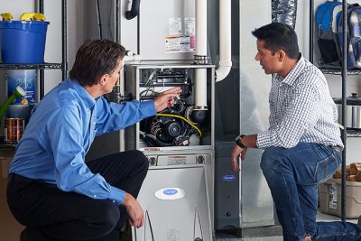 Technician evaluating a furnace for repair or replacement in Davis