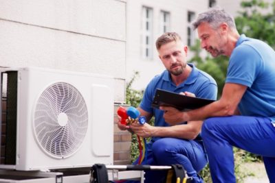 HVAC technicians installing an outdoor air conditioning unit in Davis