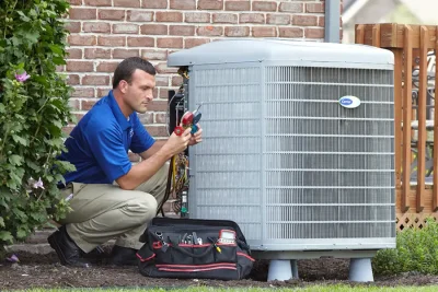 HVAC technician inspecting an outdoor AC unit in Davis